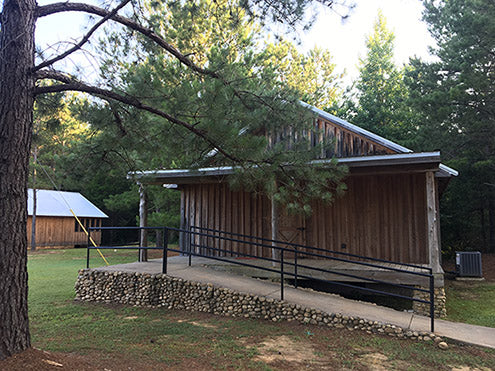 Rustic-looking cabins with beds and showers on the inside.