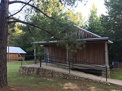 Rustic-looking cabins with beds and showers on the inside.